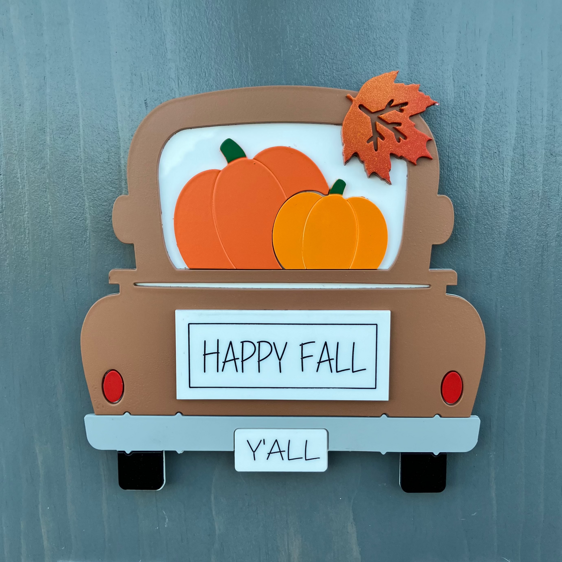 Decorative sign of a truck with pumpkins and 'Happy Fall Y'all' text on a gray background.